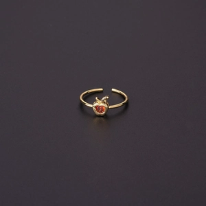 Detailed close-up of a gold-plated apple ring featuring a sparkling red heart zircon
