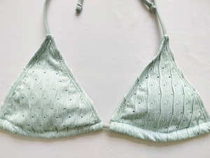 Detail eines minzgrünen gerippten Bikini-Tops mit Lochmustern und Neckholder-Bindung
