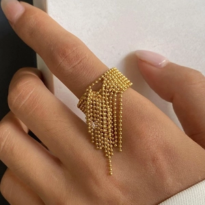 Elegant gold tassel open ring with metal beads worn on finger for a stylish luxury look