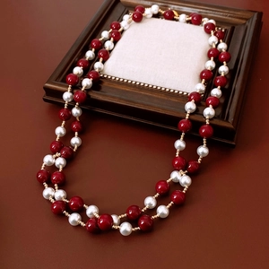 Detail view of vintage double-layer necklace with red and white beads and gold accents