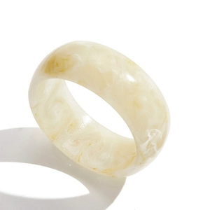 Vista dettagliata del bracciale largo in resina marmorizzata beige con finitura liscia