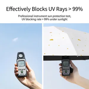 Mini white folding umbrella with gold hearts showing UV protection test results