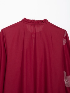 Detail of raspberry blouse back with white embroidery and ruffled neckline collar
