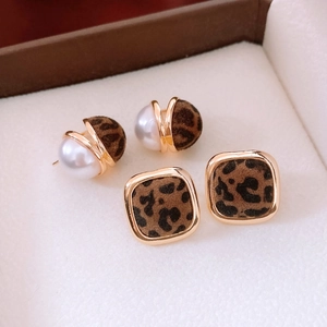 Detail of leopard print flocked earrings with pearls and gold metal geometric frames