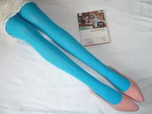 Détail d'un collant en velours bleu ciel associé à des escarpins roses sur tissu blanc