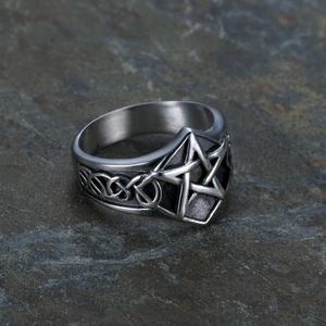 Retro punk stainless steel pentagram ring with Celtic knot details on a stone background