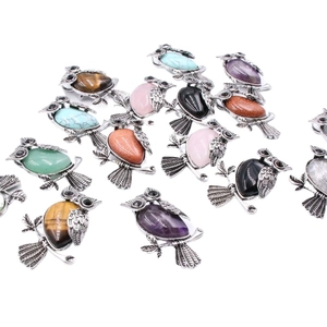 Collection of owl pendants with natural gemstones in vintage silver setting on white background
