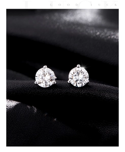 Macro shot of 1 carat moissanite stud earring with classic three-prong silver setting