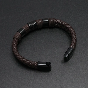 Deep brown braided leather bracelet with black magnetic buckle on matte background