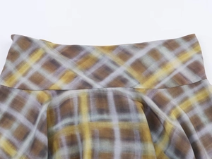 Vue macro détaillée de la texture du tissu écossais jaune et couture de la jupe