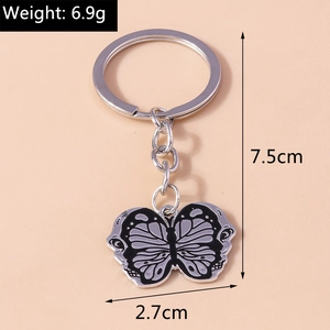 Detail of butterfly keychain showing weight 6.9g and 7.5cm length on pink background