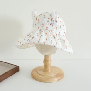 Close-up of children sun hat featuring cute rabbit ears and orange tulip floral patterns