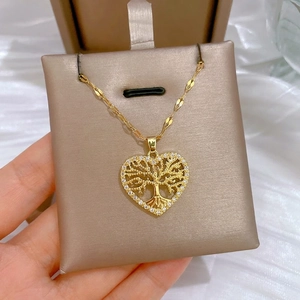 Elegant gold heart necklace with life tree design and crystal pavé on velvet base
