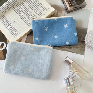 Detail of star-print denim pouches with zippers for makeup and small essentials
