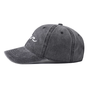 Detail of dark gray washed cotton baseball cap featuring white wave embroidery on the side