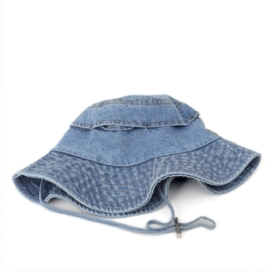 Detail of blue denim bucket hat showing wide brim stitching and adjustable drawstring