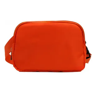Detail of bright orange nylon crossbody bag with black buckle and matching woven strap
