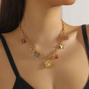 Golden floral necklace with colorful drop pendants and pearls on a female model