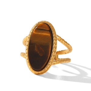 Macro detail of oval tiger eye stone set in a vintage hammered gold stainless steel ring