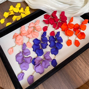 Detailed view of colorful rose petal tassel earrings neatly arranged on a tray