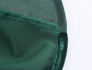 Detail of dark green velvet hem with double stitching on elegant long sleeve dress