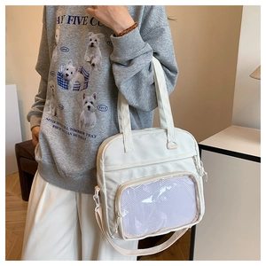 White canvas ita bag with transparent display window shown on model wearing grey hoodie