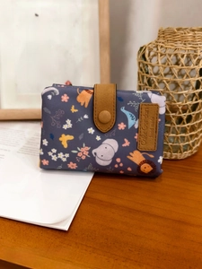 Close-up of small elephant pattern wallet on wooden desk with handmade leather strap