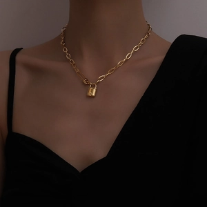 Gold chunky chain necklace with padlock pendant worn by a model in retro street style