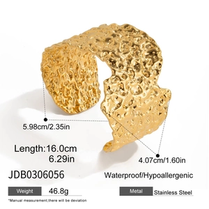 Detailed macro view of gold-plated stainless steel bangle with hammered texture surface