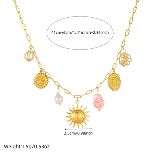 Close-up of vintage gold sun and moon pendant with pink heart and pearls on necklace