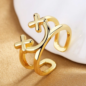 Close-up of double-layered gold adjustable ring with polished cross patterns