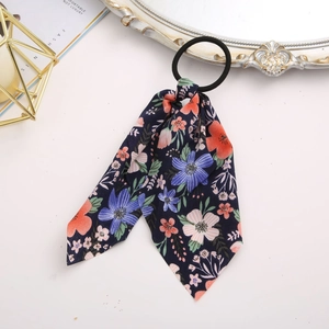 Detail of floral scrunchie with navy blue ribbon on white table with vintage decor