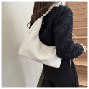 Detail of white glossy leather hobo bag with trendy pleated ruffle shoulder strap design