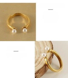 Détail d'une bague ouverte en acier inoxydable plaqué or 18k avec deux perles blanches