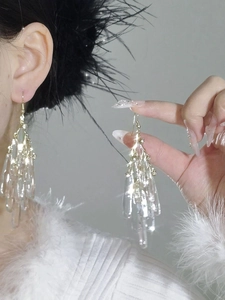 Detail of long cascading acrylic fringe earrings with crystal texture and gold hardware