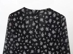 Detail van bloemen chiffon jurk met ronde hals en onzichtbare rits aan de achterkant