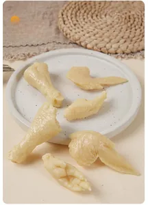 Close-up of realistic PVC chicken wing and foot food models on a ceramic plate