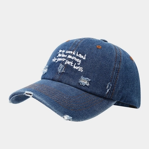 Close-up of vintage blue denim baseball cap with white embroidery and distressed details