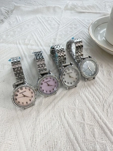 Detail of four silver women watches with crystal bezels and multi-colored dials
