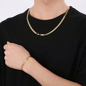 Minimalist gold flat curb chain necklace and bracelet set on a black T-shirt model