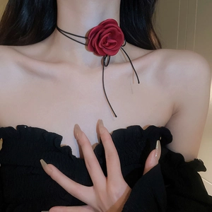 Close-up of red fabric rose choker necklace with elegant long ribbons on model