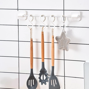 White S-shaped kitchen hooks on a stainless steel bar for home organization
