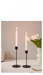 Detail of minimalist black iron candle holders on elegant wrinkled fabric background