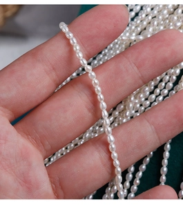 Macro detail of 2.5mm natural white freshwater seed pearls held in hand for DIY jewelry