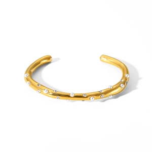 Dettaglio del bracciale aperto placcato oro 18k con perle e cristalli su metallo ondulato