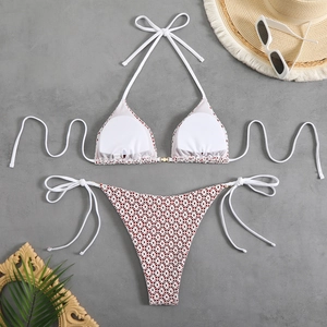 Flat lay of a white floral halter bikini set with straw hat and sunglasses for summer
