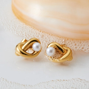 Elegant gold knot stud earrings with center pearl detail and polished 316L stainless finish