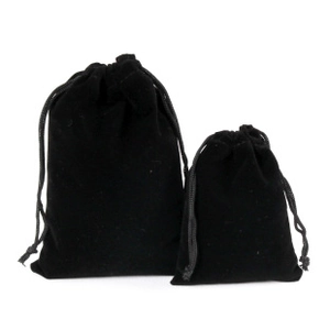 Close-up of black velvet drawstring pouches in two sizes showing soft fabric texture