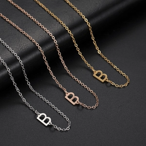 Detailed macro view of letter B pendants in silver, gold, and rose gold stainless steel
