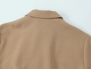 Détail du col à revers et texture du tissu sur une veste bouffante pour femme couleur camel